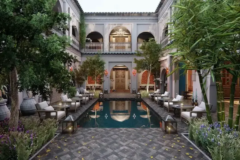 Riad: patio con alberca, palmeras y galería de arcos