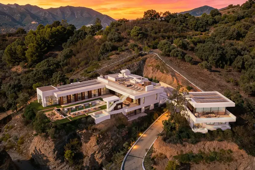 The House (Marbella): vista aérea de la villa en la ladera al atardecer