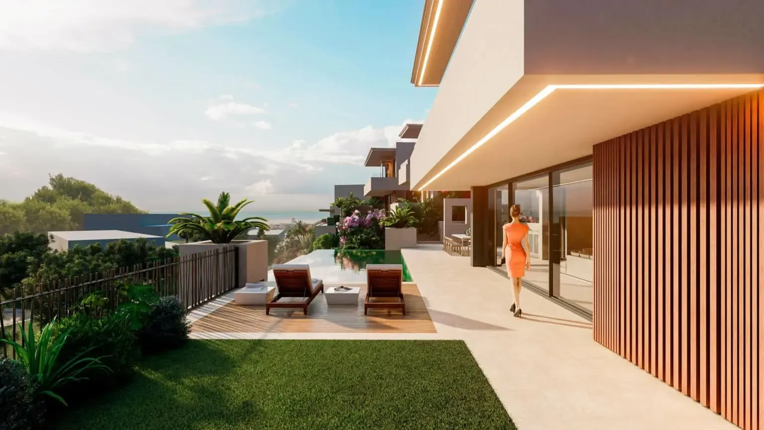 Outdoor walkway at 7 Heaven with a figure walking beside the timber cladding, sun loungers, pool and garden with the sea behind
